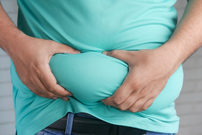 A person holding their belly fat